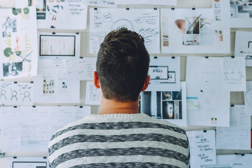 man looking at a wall of diagrams