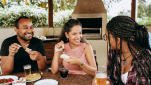 A group of individuals celebrate with drinks and food.